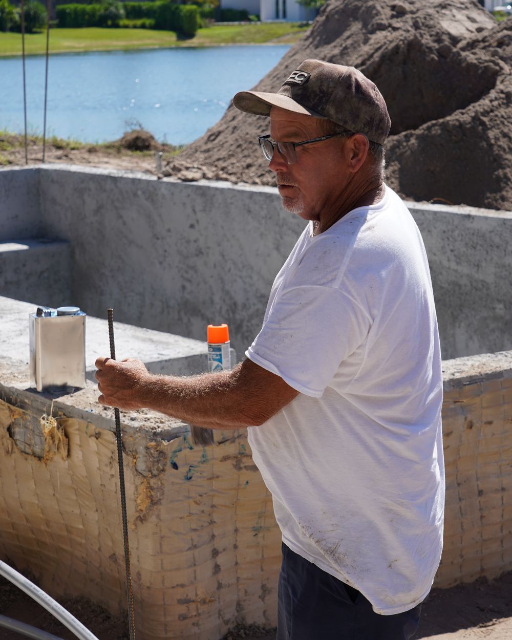 Ben of Top Tier Pools beside a new pool shell