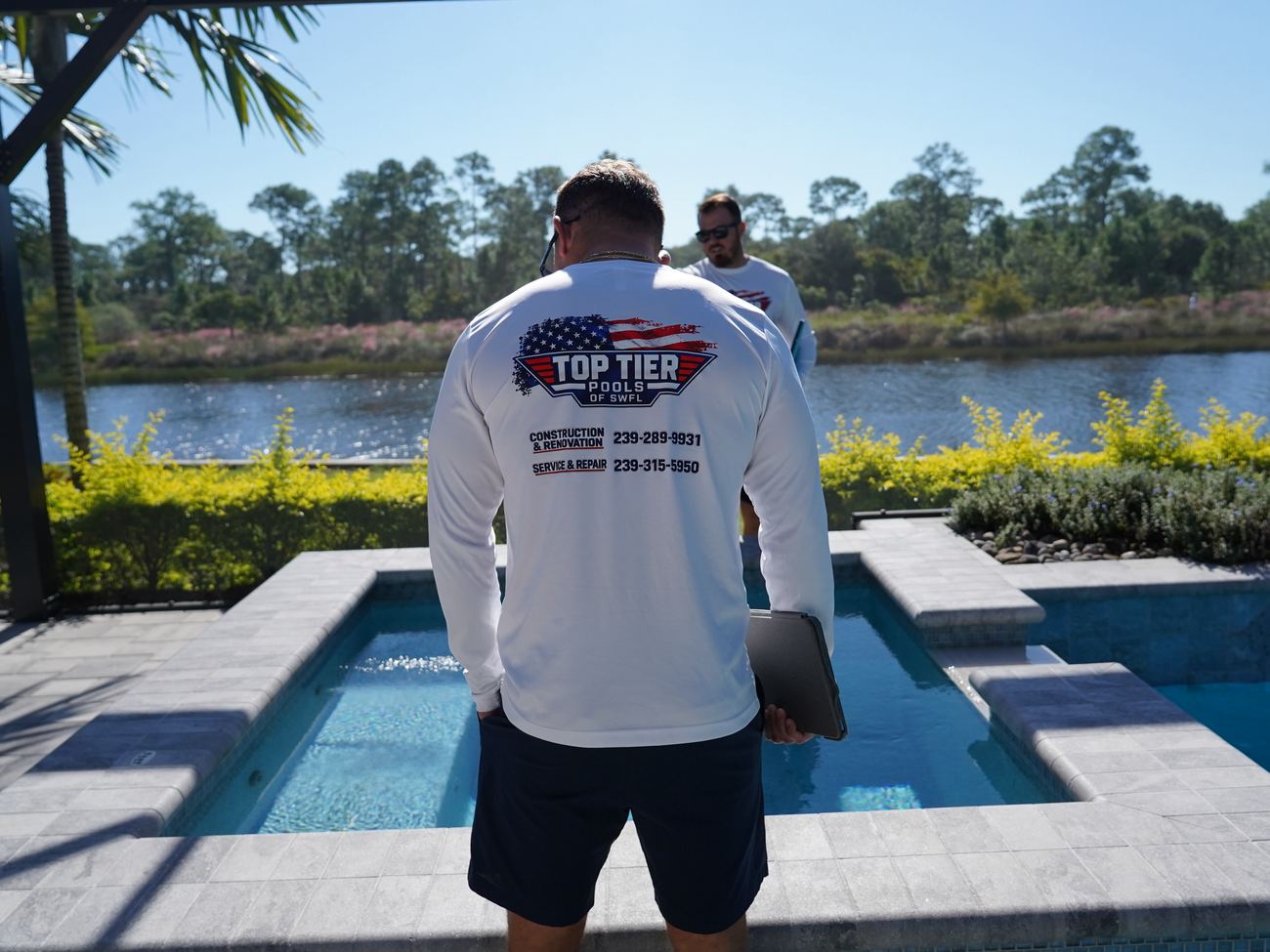 Blaine of Top Tier Pools on a finished lakefront spa job in Naples