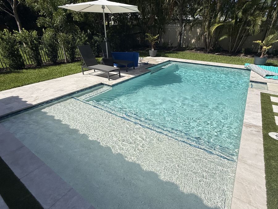 Pool with a large sun shelf and umbrella