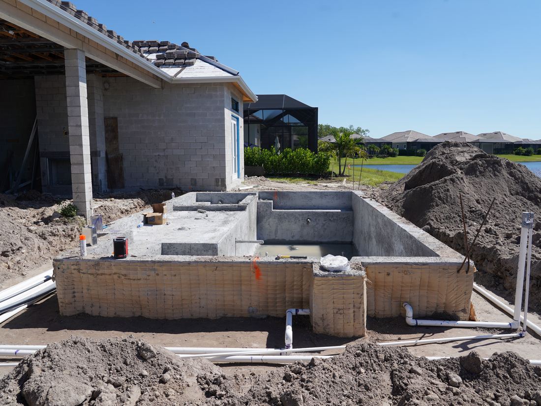 Concrete shell of a new pool with sun shelf and spa in Naples