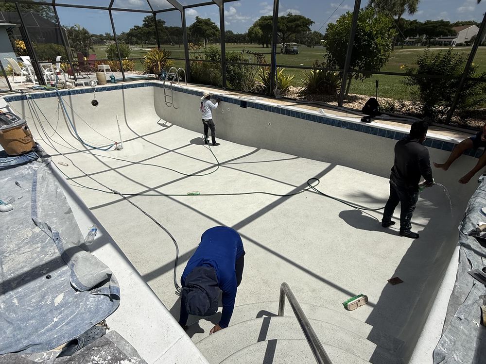 Crew applying new plaster during pool resurfacing