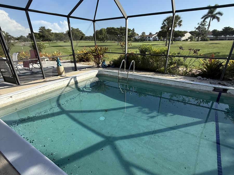 Pool before renovation with failing surface and chipped tile